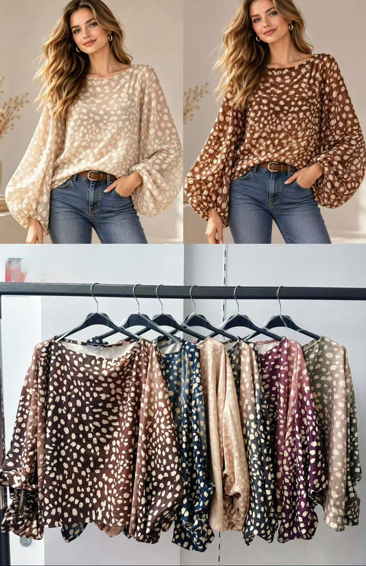 Spotted print tops in assorted colors, shown worn and hanging on a rack.