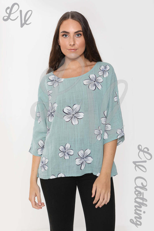 Ladies teal daisy print top with wide round neckline and three-quarter sleeves
