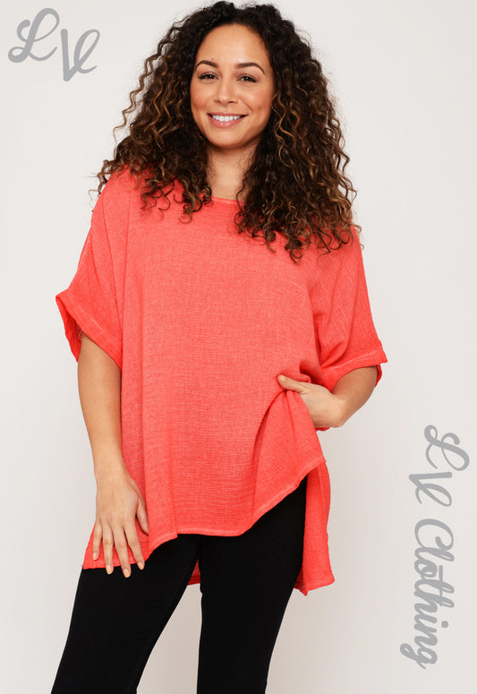 Coral short-sleeve cotton tunic with draped hem and relaxed fit