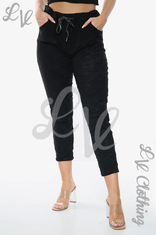 Black suede-look jogger pants with drawstring waist and cuffed ankle hem, side pockets