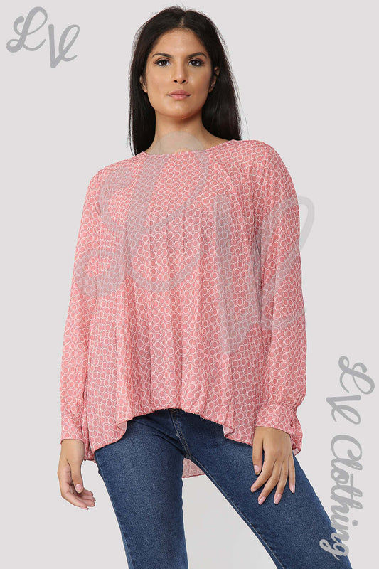 Salmon circle-print pleated blouse with long sleeves and loose drape