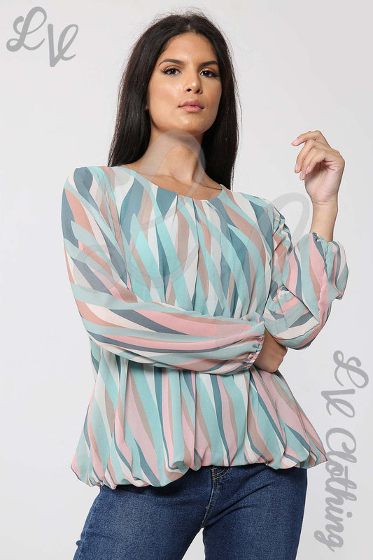 Geometric print blouse in teal, pink, and white with long sleeves and boat neckline