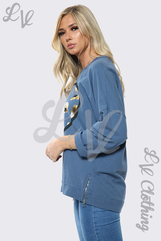 Oversized blue sweatshirt with gold foil heart graphic, side view, long sleeves