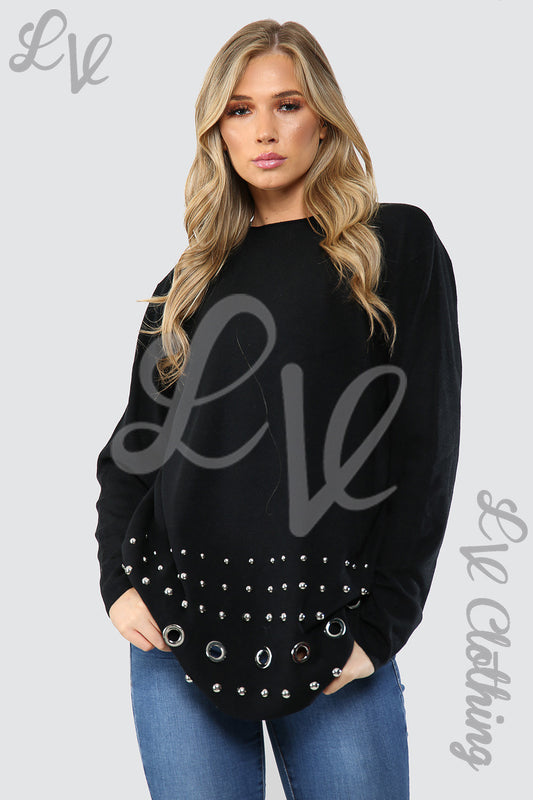 Black jumper with studded hem panel and small grommet-like accents at sleeves