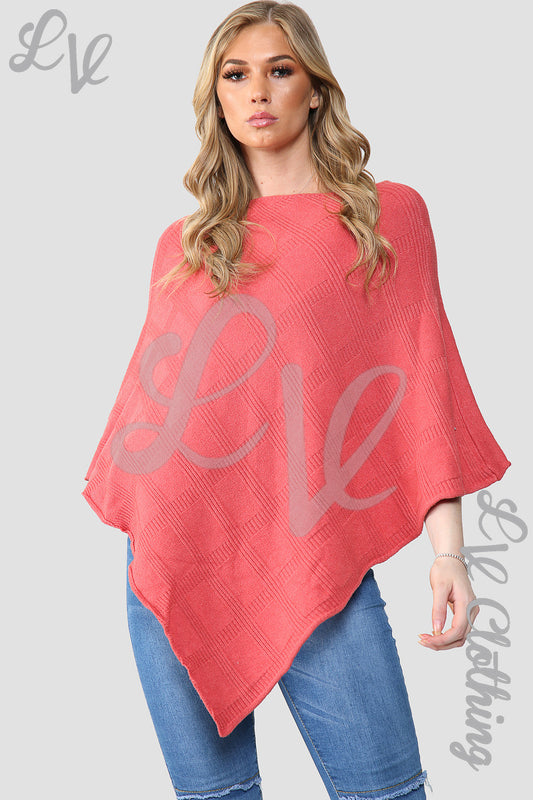 Coral knitted poncho cape with diamond imprint, wide sleeves, worn over blue jeans
