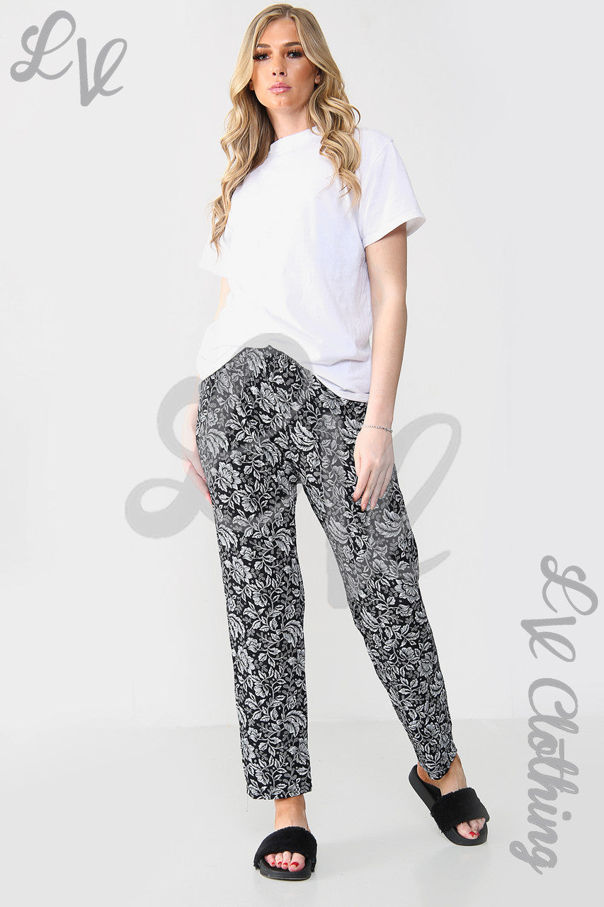 Black leaf-outline print trousers with elastic waist and straight leg