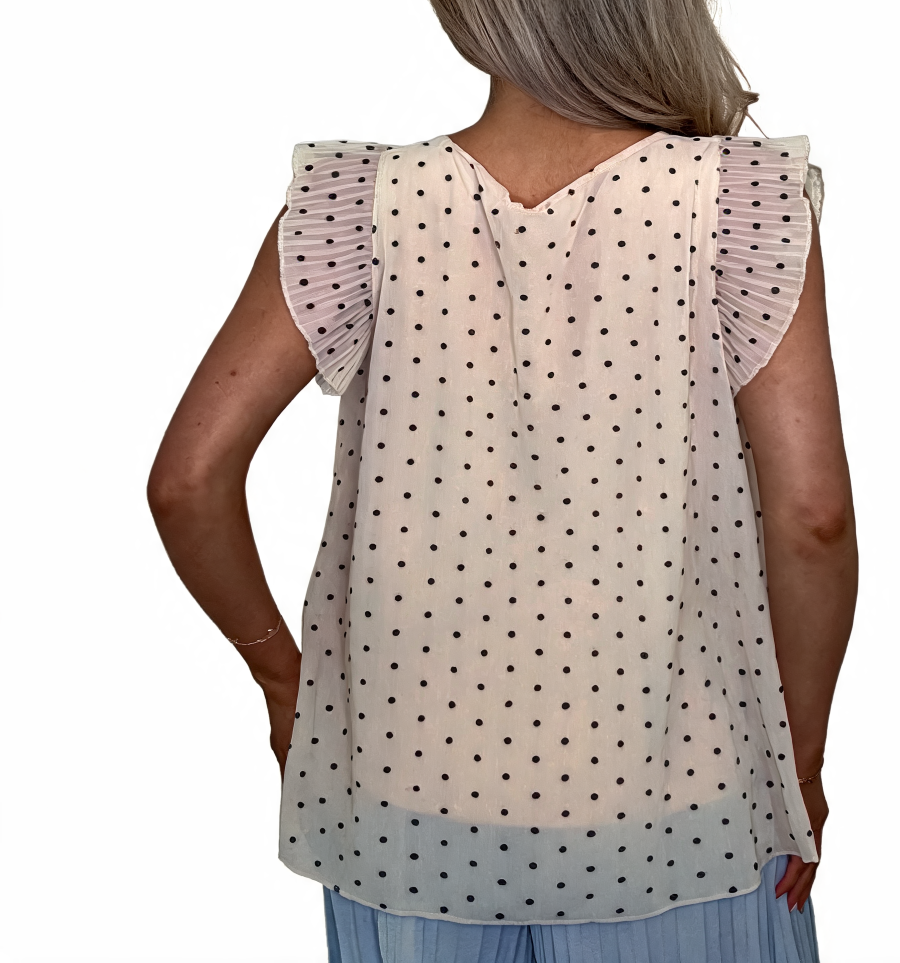Back view: white polka dot swing top with ruffle sleeves and V-back yoke