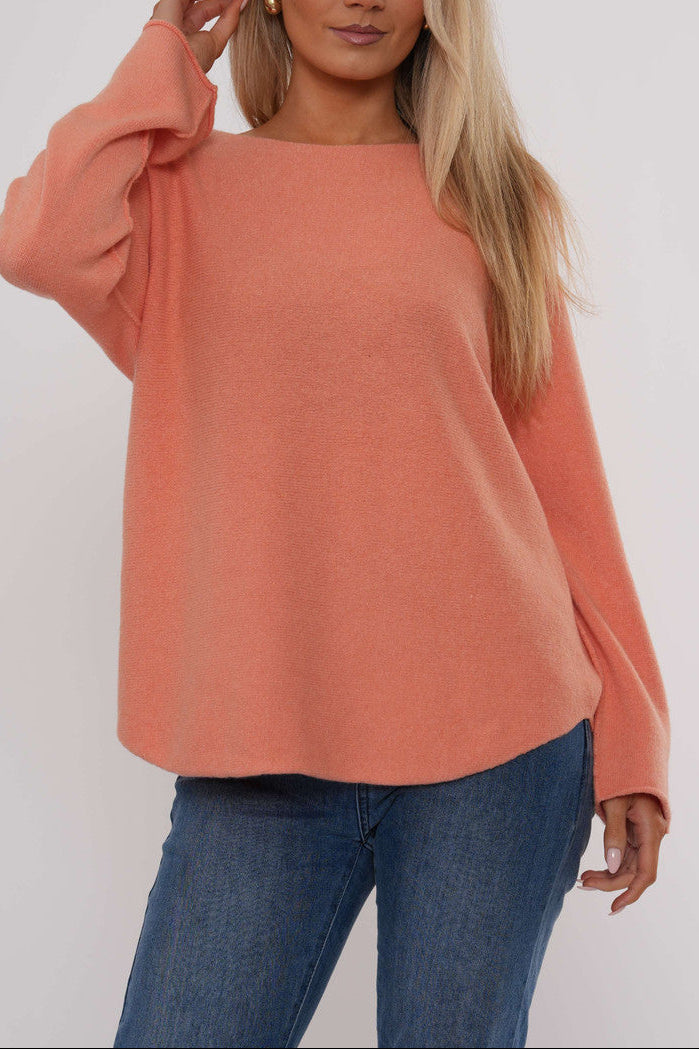 Coral pink boat neck knit sweater with long sleeves and relaxed curved hem